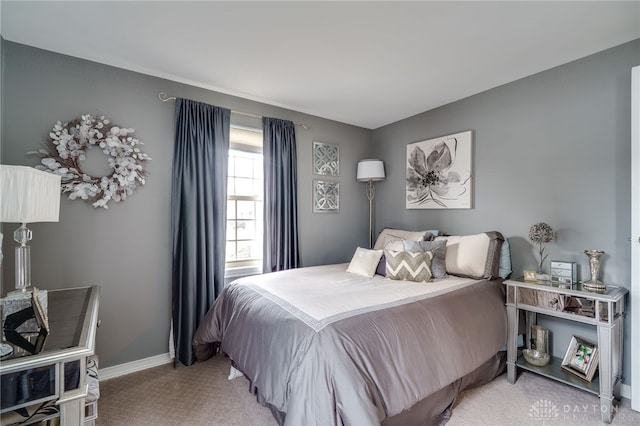 bedroom featuring light carpet and baseboards