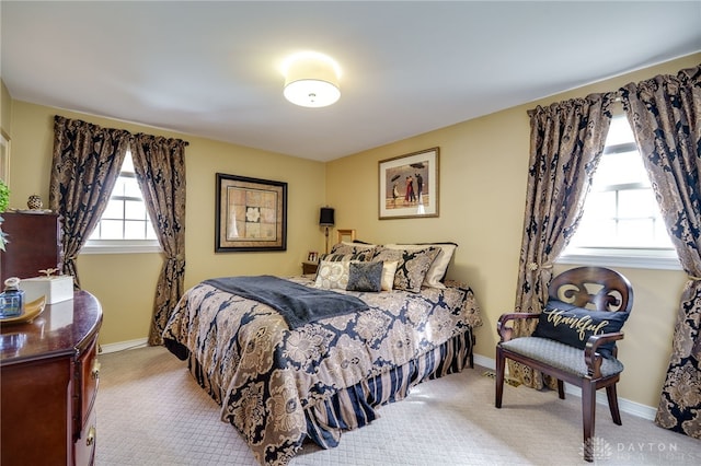 bedroom featuring baseboards and light colored carpet