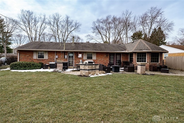 rear view of house featuring brick siding, a patio, fence, and a lawn