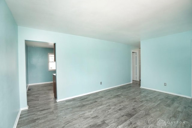 unfurnished room featuring baseboards and wood finished floors