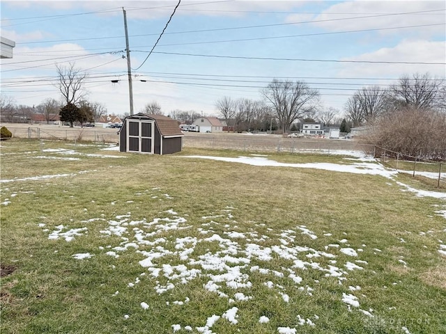 view of yard featuring a shed, an outdoor structure, and fence