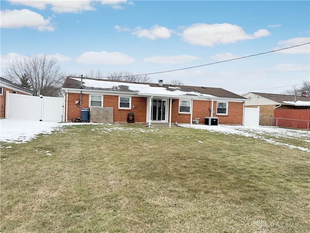 single story home with a gate, fence, central air condition unit, a front lawn, and brick siding