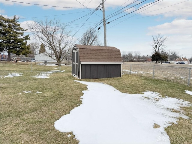 view of yard featuring a storage unit, an outdoor structure, and fence