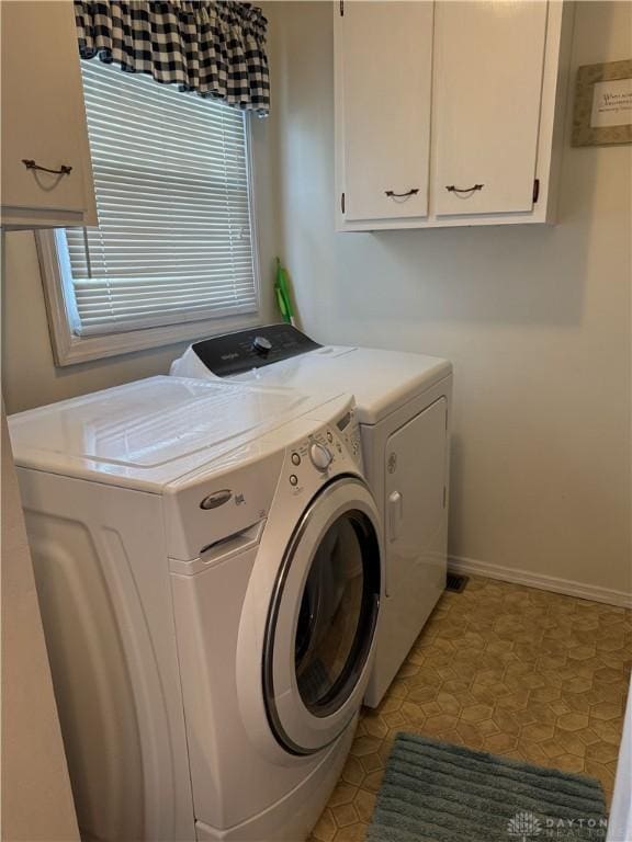 laundry room with washing machine and dryer, cabinet space, and baseboards