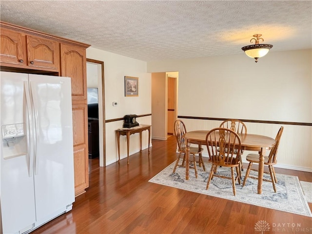 dining room featuring dark wood-style floors and a textured ceiling