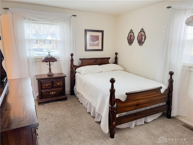 bedroom featuring visible vents and light carpet