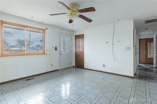 unfurnished room with baseboards, visible vents, a textured ceiling, and light floors