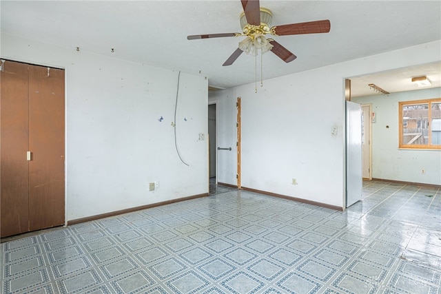 unfurnished room with light floors, ceiling fan, and baseboards