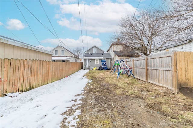 yard covered in snow with a fenced backyard