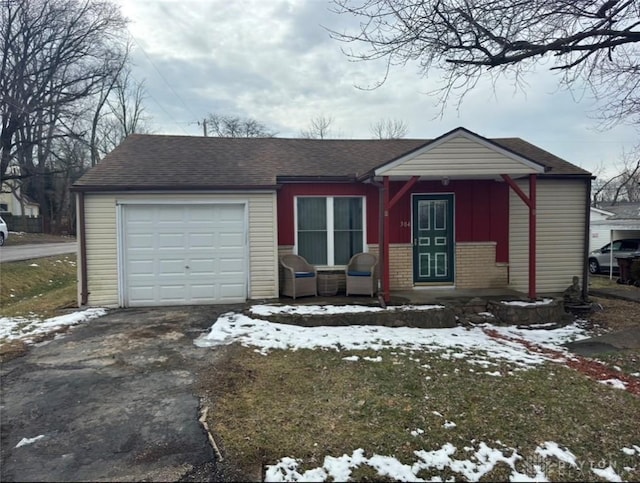 view of front of home featuring driveway, roof with shingles, an attached garage, board and batten siding, and brick siding