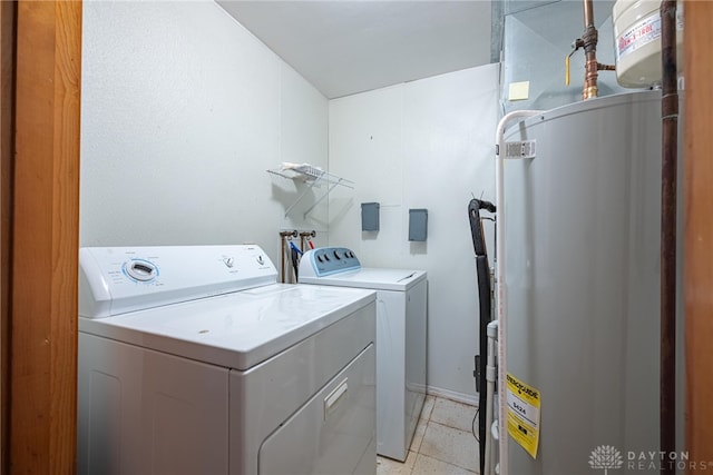 washroom featuring laundry area, water heater, washer and dryer, and light tile patterned flooring