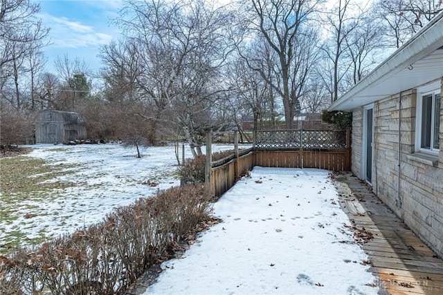 yard covered in snow featuring fence