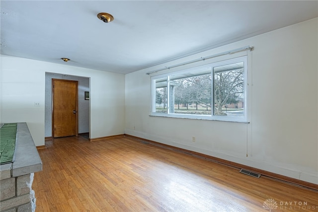 unfurnished room featuring baseboards, visible vents, and light wood finished floors