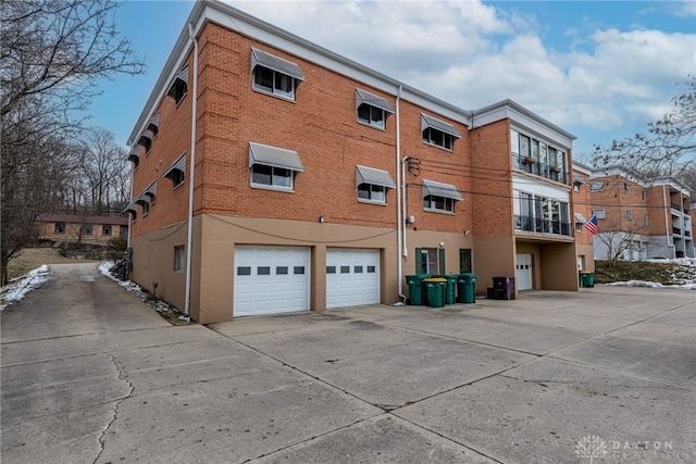 view of building exterior featuring driveway and an attached garage