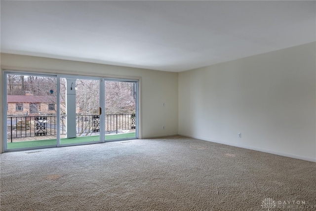 empty room featuring plenty of natural light, baseboards, and carpet flooring