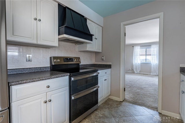 kitchen with light carpet, range with two ovens, dark countertops, custom range hood, and white cabinetry