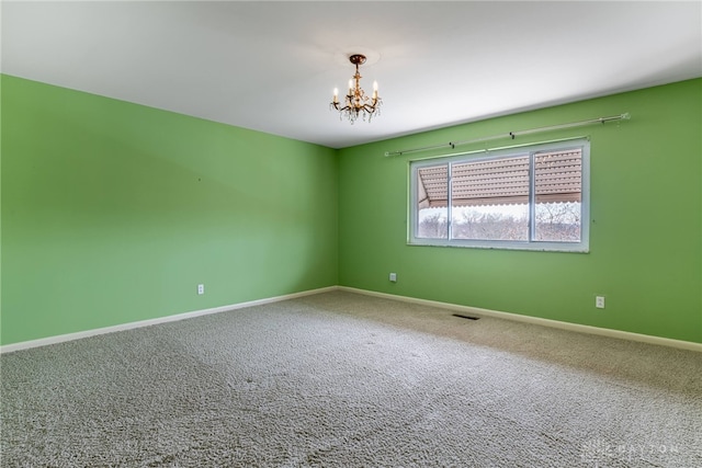 empty room with a chandelier, carpet floors, and baseboards