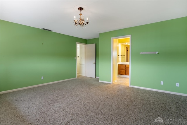 unfurnished bedroom with visible vents, baseboards, ensuite bathroom, an inviting chandelier, and carpet