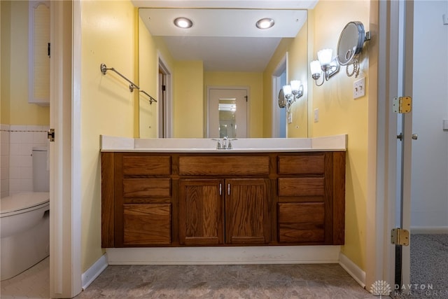 bathroom featuring toilet, baseboards, and vanity