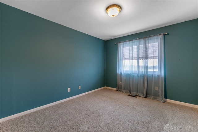 carpeted empty room with baseboards