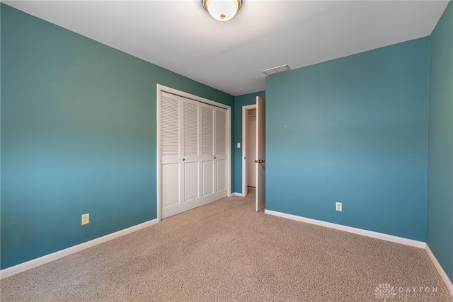 unfurnished bedroom featuring carpet floors, visible vents, and baseboards