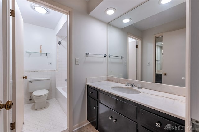 bathroom with toilet, shower / bath combination, vanity, tile walls, and tile patterned floors