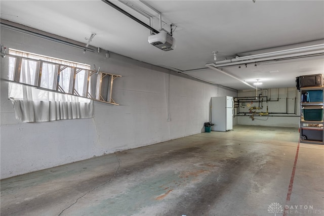 garage with freestanding refrigerator and a garage door opener