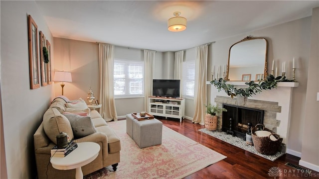 living room with a fireplace, wood finished floors, and baseboards