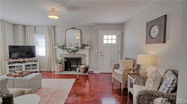 interior space with a fireplace with flush hearth, baseboards, and wood finished floors