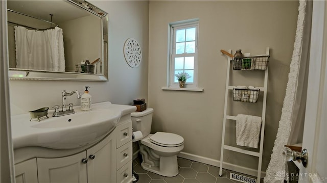 bathroom featuring toilet, baseboards, visible vents, and vanity