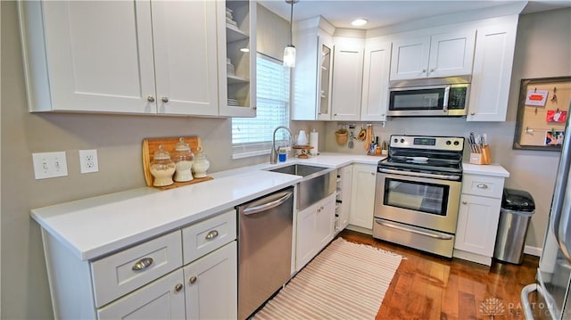 kitchen featuring stainless steel appliances, glass insert cabinets, and white cabinets