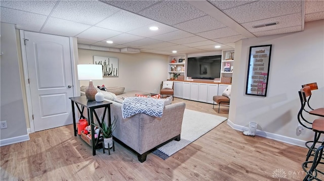 living room featuring recessed lighting, light wood-type flooring, visible vents, and baseboards