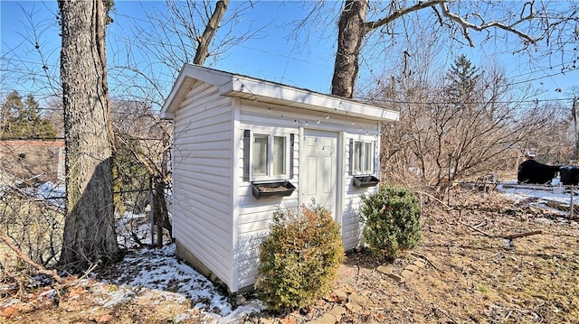 snow covered structure featuring an outbuilding