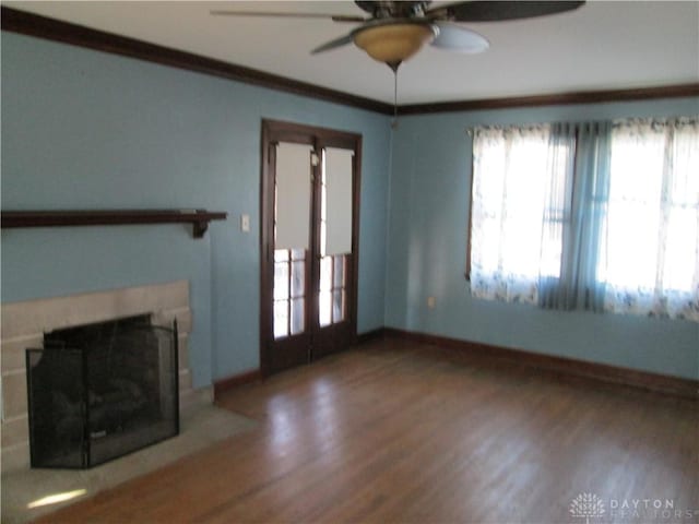 unfurnished living room with ornamental molding, a fireplace, wood finished floors, and baseboards