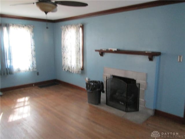 unfurnished living room with a fireplace, baseboards, and wood finished floors