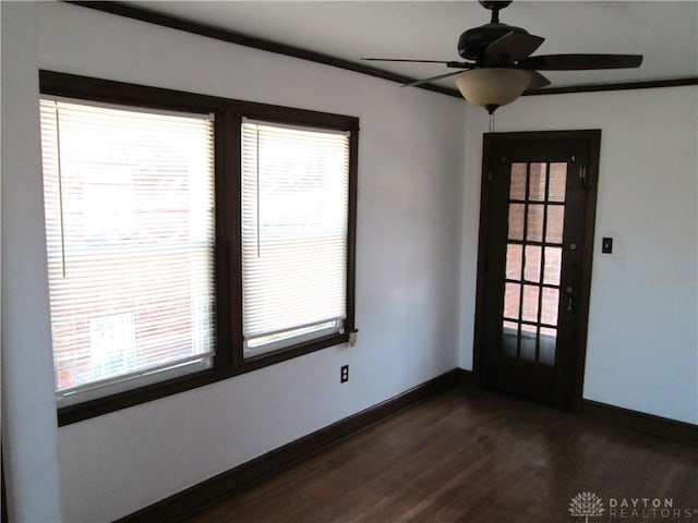 unfurnished room featuring dark wood-style floors, ceiling fan, and baseboards