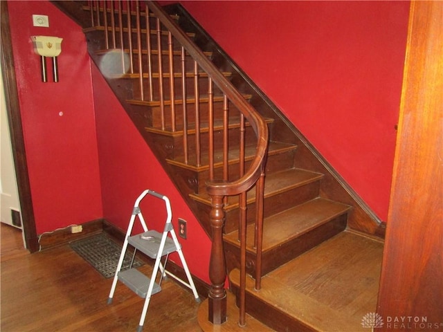 staircase with baseboards and wood finished floors