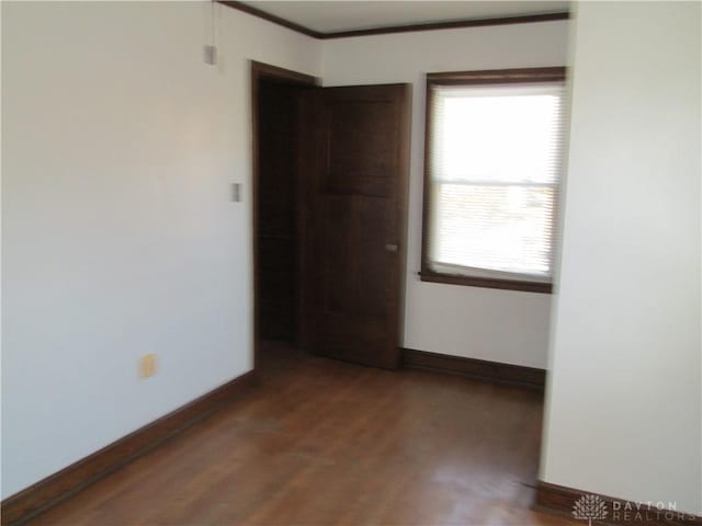 unfurnished room with baseboards and wood finished floors