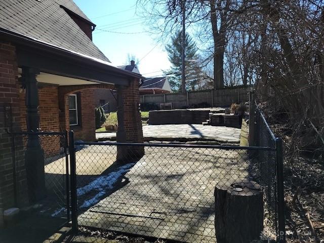 exterior space with a patio area, a fenced backyard, and brick siding