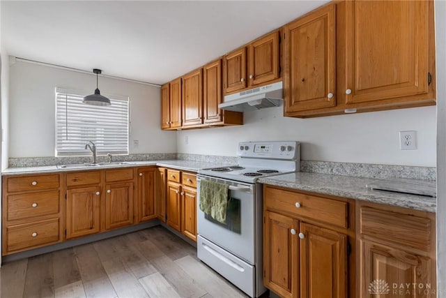 kitchen featuring light wood finished floors, white range with electric stovetop, hanging light fixtures, under cabinet range hood, and a sink