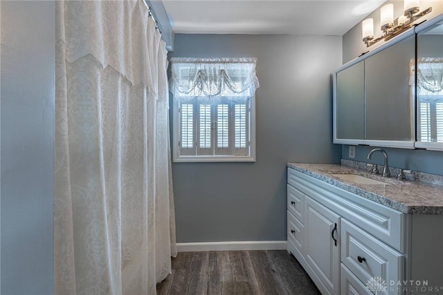 bathroom featuring wood finished floors, vanity, and baseboards