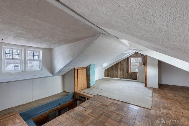 additional living space with lofted ceiling and a textured ceiling