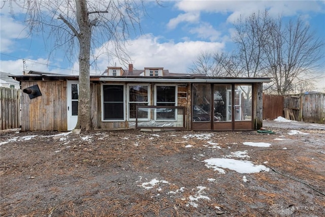 view of front of house featuring a sunroom and fence