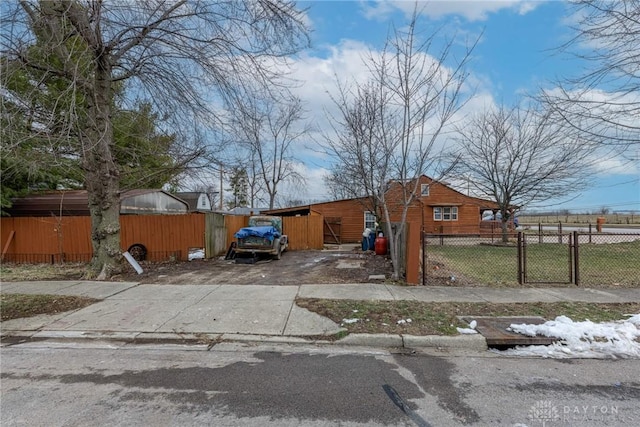 bungalow featuring a fenced front yard, a gate, and driveway