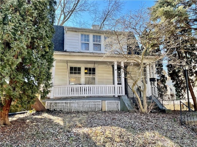 view of front of home featuring a porch, roof with shingles, fence, and a chimney