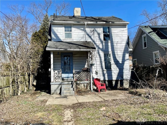 view of front of home featuring covered porch and a chimney