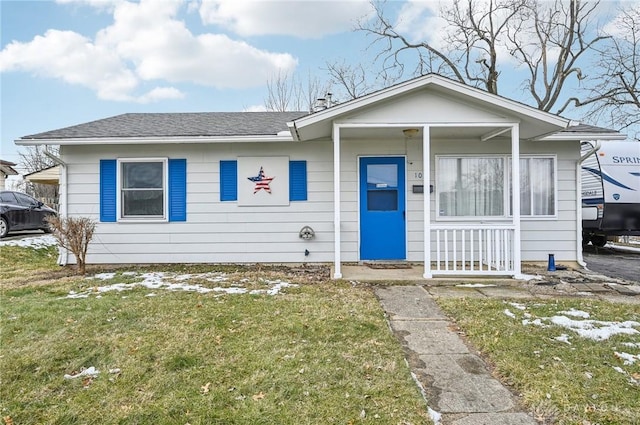 view of front of home featuring a front lawn, a porch, and a shingled roof