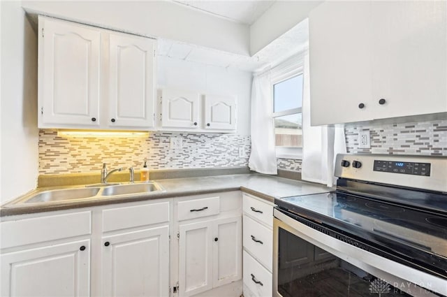 kitchen featuring a sink, white cabinetry, light countertops, stainless steel electric range, and backsplash