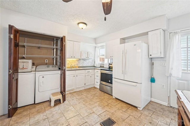 kitchen featuring visible vents, white cabinetry, light countertops, freestanding refrigerator, and stainless steel range with electric stovetop