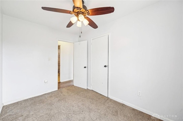 unfurnished bedroom with ceiling fan, a closet, baseboards, and carpet flooring